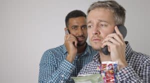 Two men on the phone look concerned.