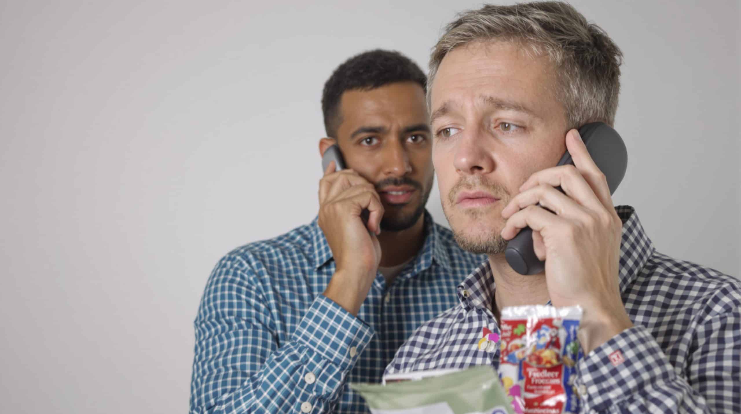 Two men on the phone look concerned.